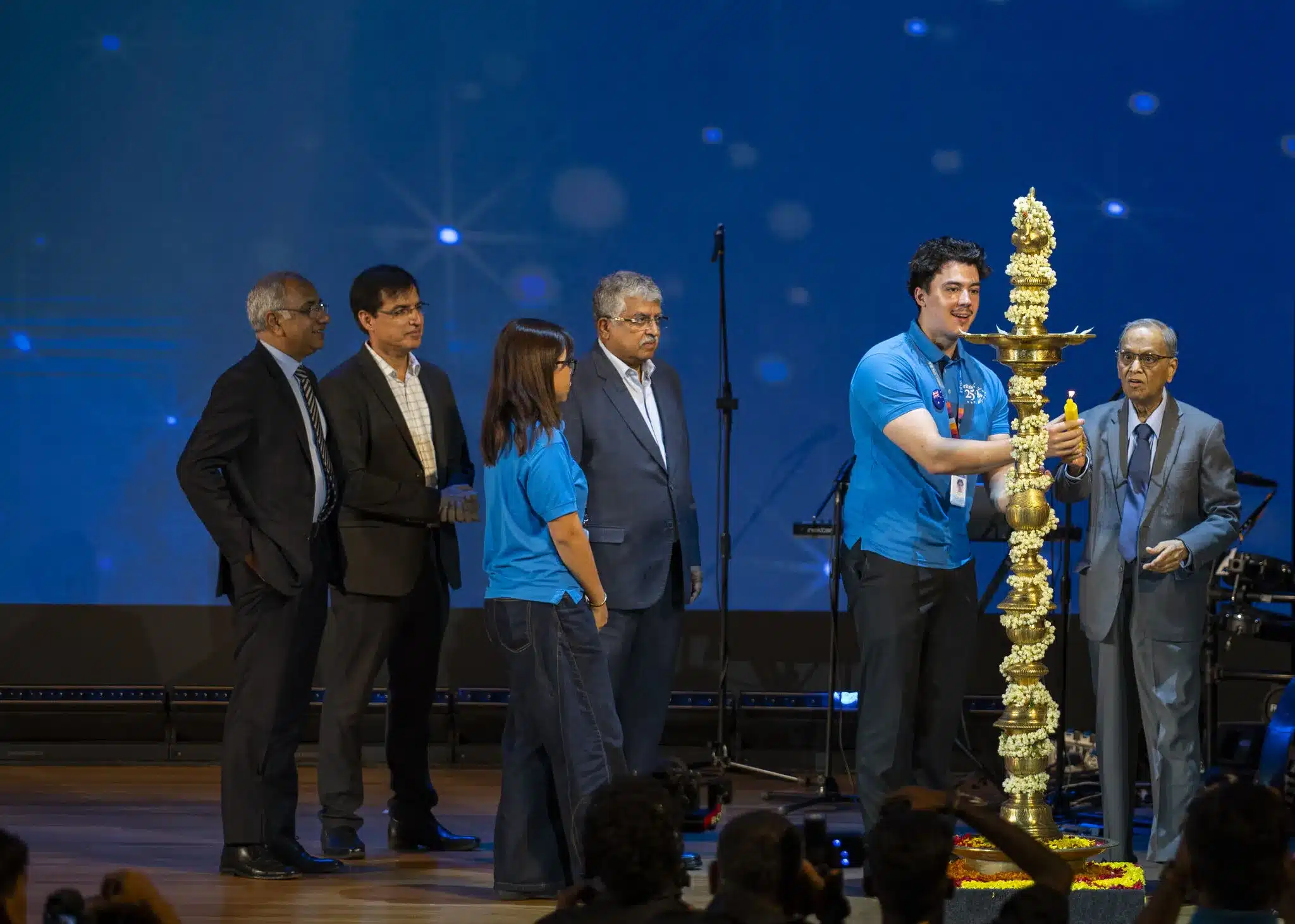 Xander lights the Nilavilakku (traditional ceremonial lamp) at Infosys InStep’s 25th anniversary, alongside the company’s founder and executive leadership.